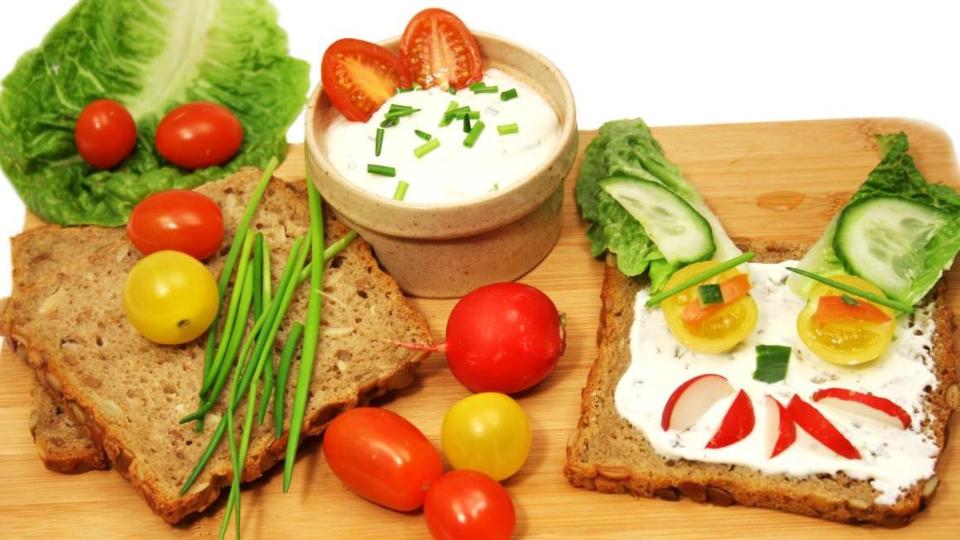 Mit Gemüsesorten und Salat dekorierte Brotscheibe