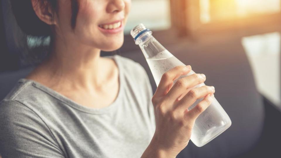 Frau trinkt Wasser aus der Flasche