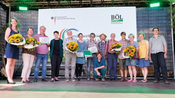 Gruppenfoto der Gewinnerinnen und Gewinner mit Staatssekretärin Silvia Bender auf der Bühne